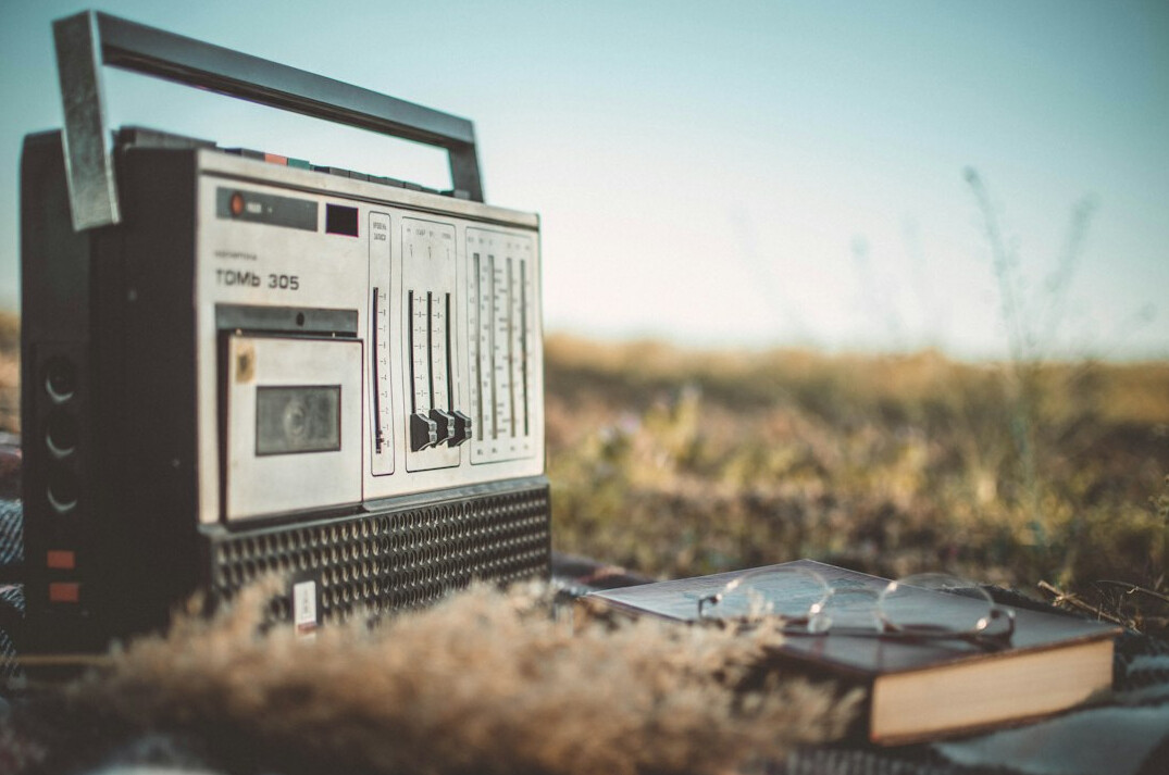 Headphones resting on a vintage radio with a notebook