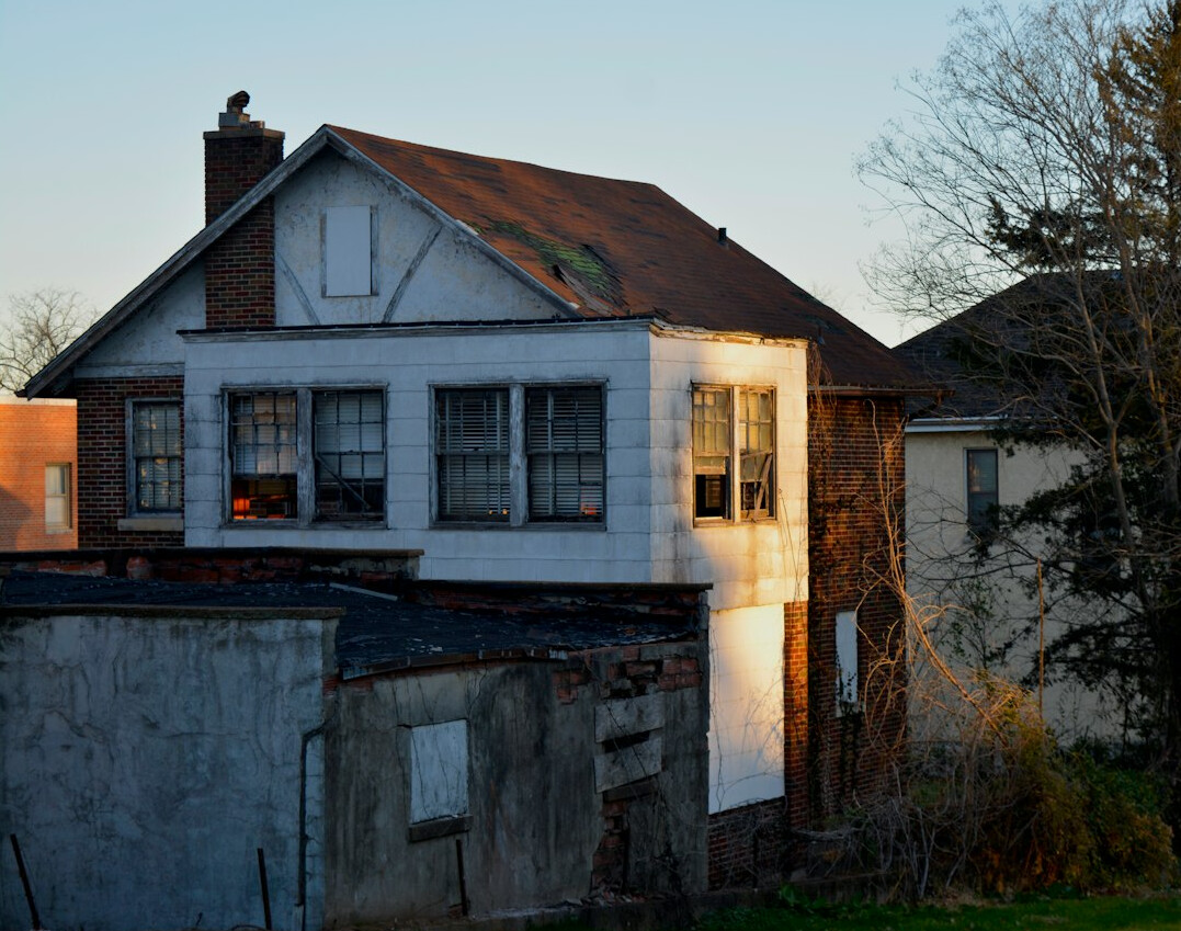 Old abandoned house at dusk with a single lit window
