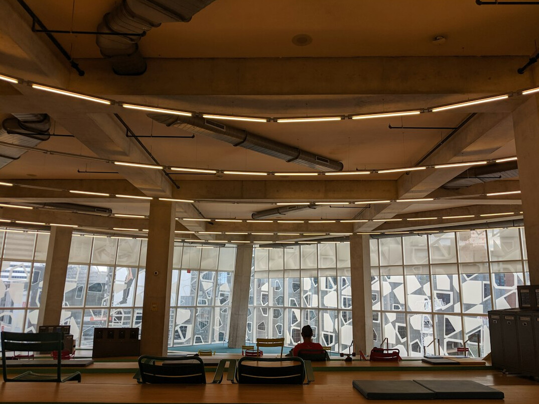 Modern open-plan newsroom with large windows and laptops