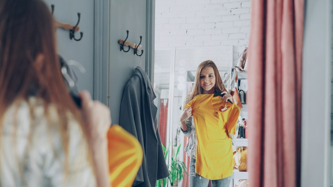 woman trying on coat in store